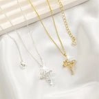 Silver and gold crown cross necklaces side by side